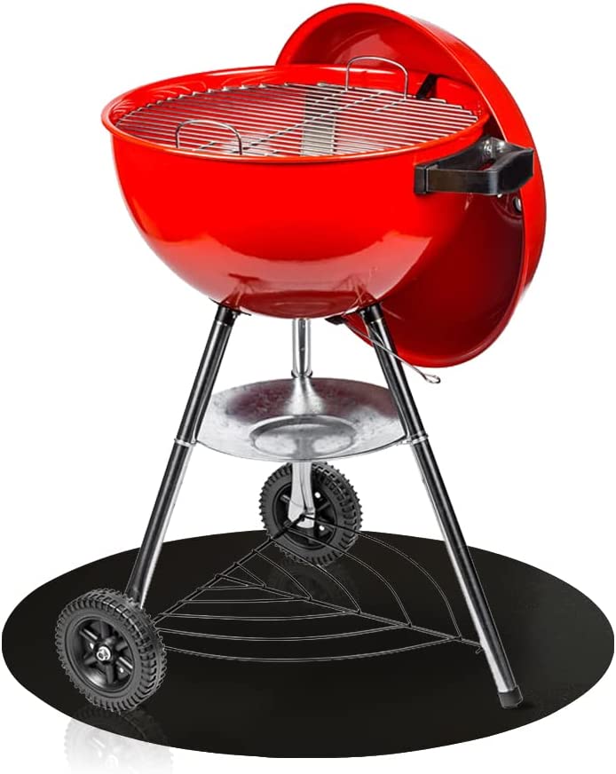 Smaller red charcoal grill on top of black grill mat with smooth textured top