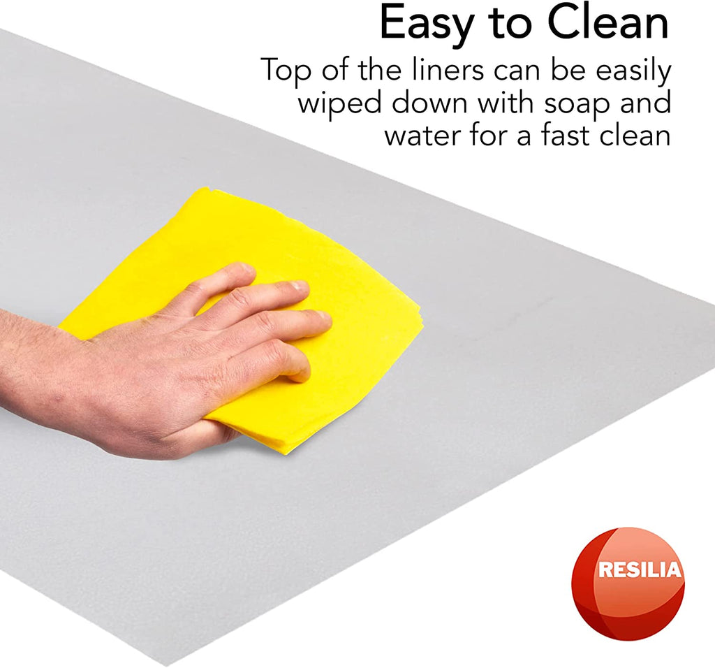 Hand with yellow cloth easily cleaning the clear shelf liner. Top of the liners can be easily wiped down with soap and water for a fast clean