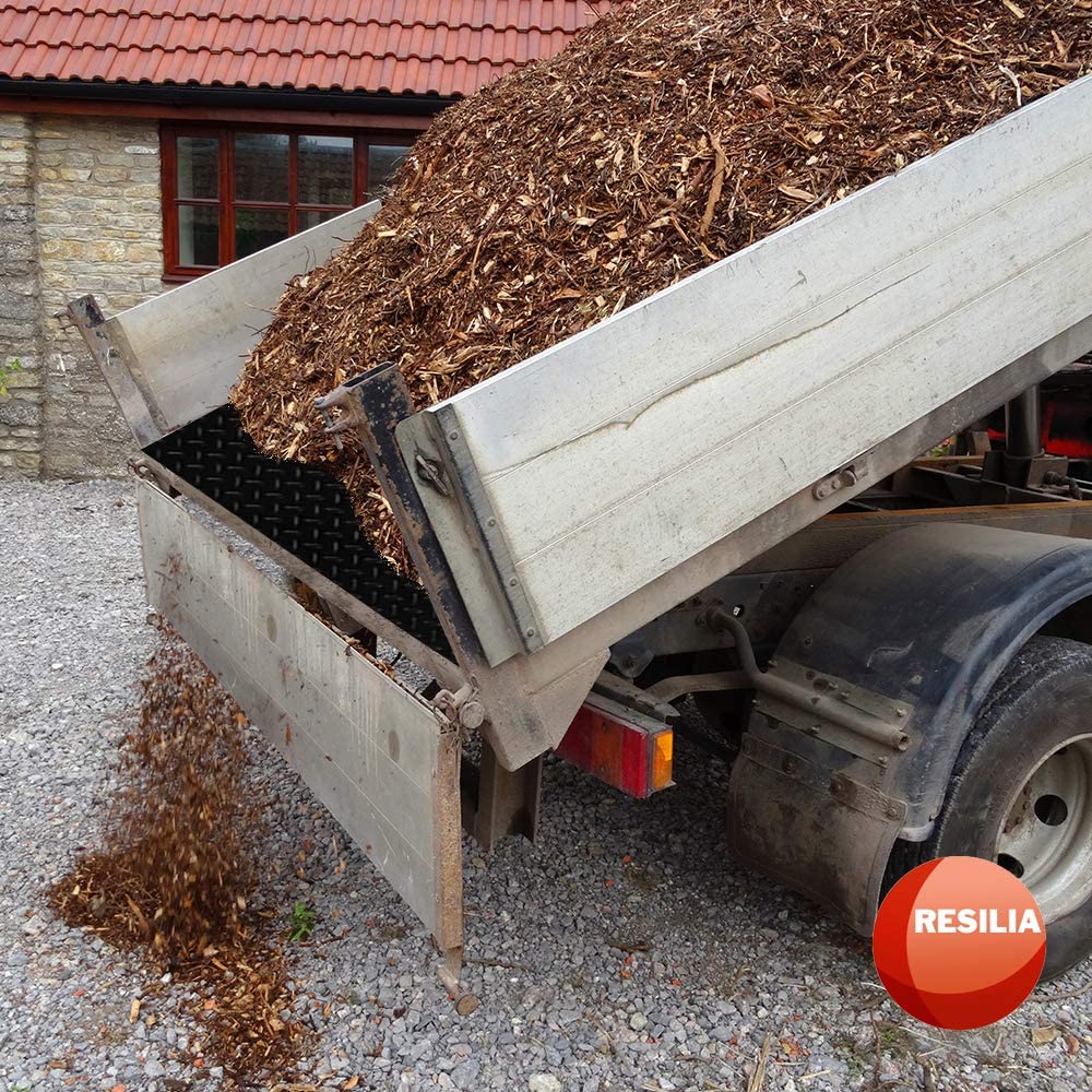 Wood chips being dumped from a truck lined with a truck bed mat liner