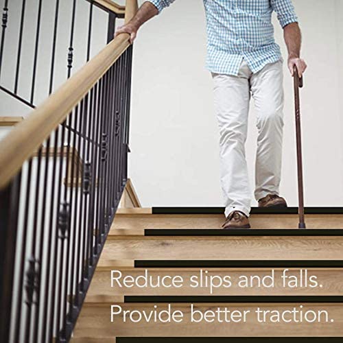 Man with cane holding railing downstairs. Stair treads reduce slips and falls as well as provide better traction