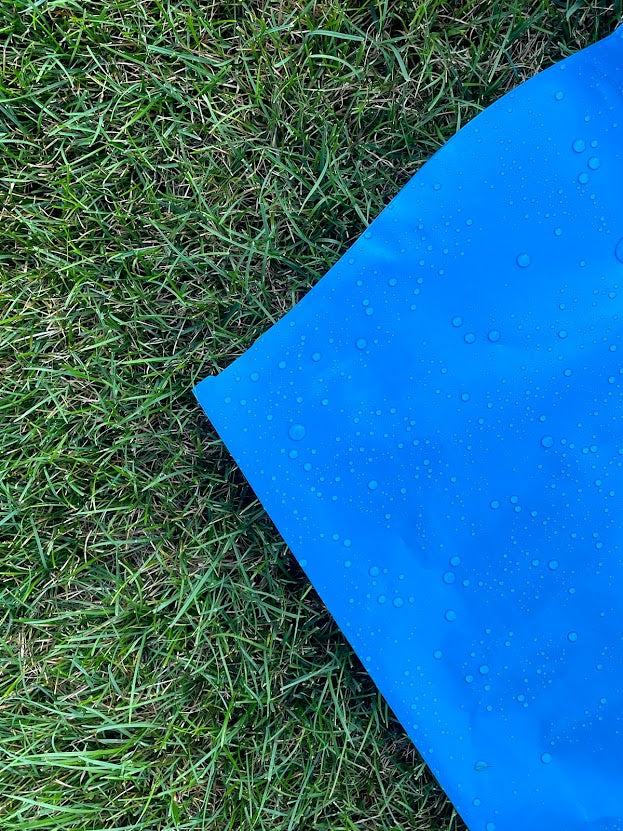 Corner of super slip water slide with water droplets on grass