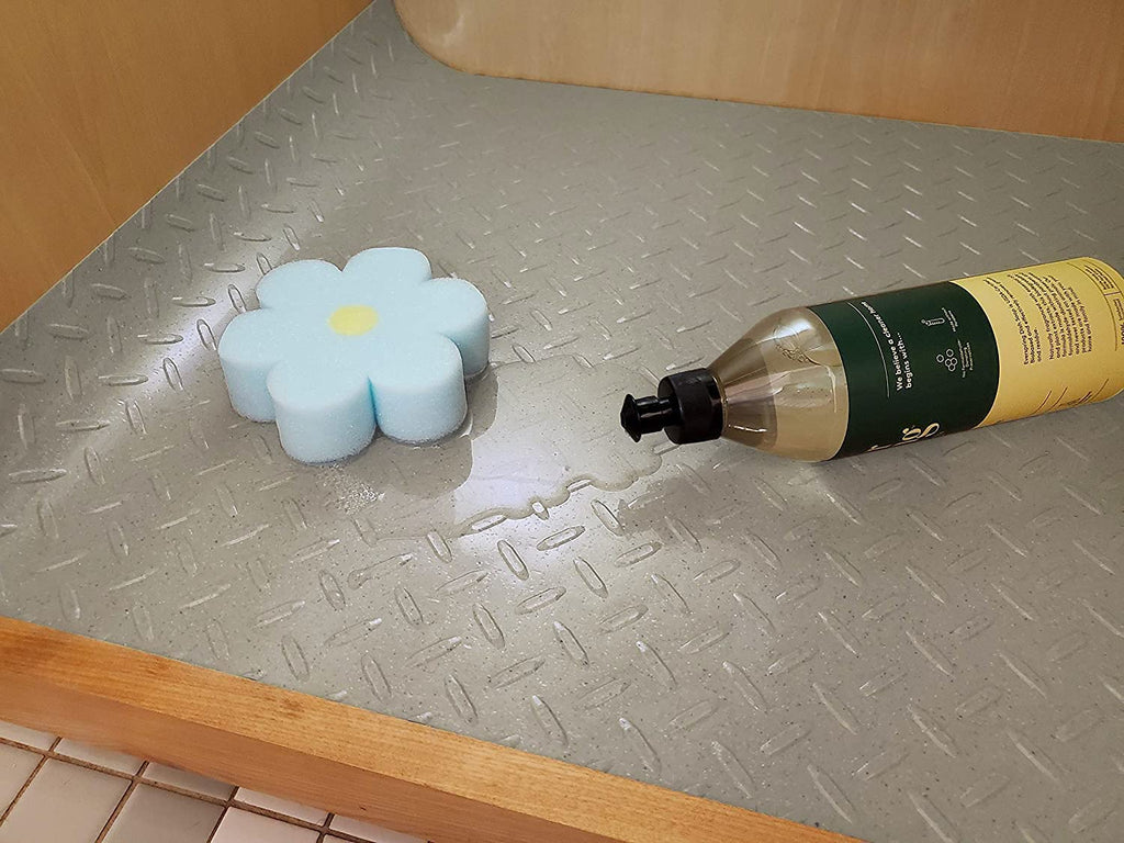 Under sink mat with sponge, water and soap tipped over