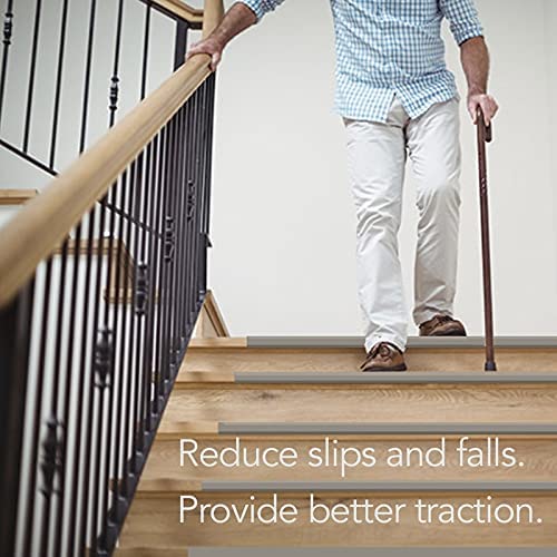 Man with cane holding railing downstairs. Stair treads reduce slips and falls as well as provide better traction